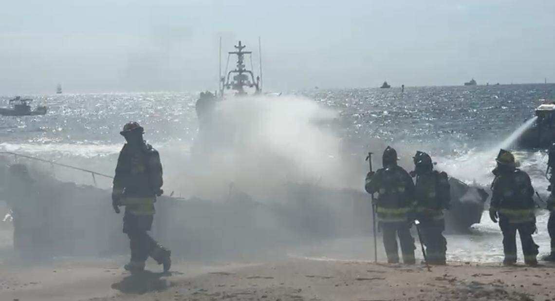 Firefighters spray down a burning 30-foot boat that went up in flames off the beach in Fort Lauderdale Wednesday, May 28, 2025.