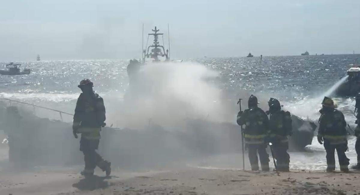 Los bomberos rocían un barco de 30 pies que ardió en llamas frente a la playa de Fort Lauderdale el miércoles 28 de mayo de 2025. 