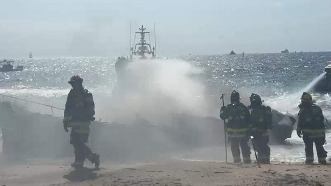 Firefighters spray down a burning 30-foot boat that went up in flames off the beach in Fort Lauderdale Wednesday, May 28, 2025.