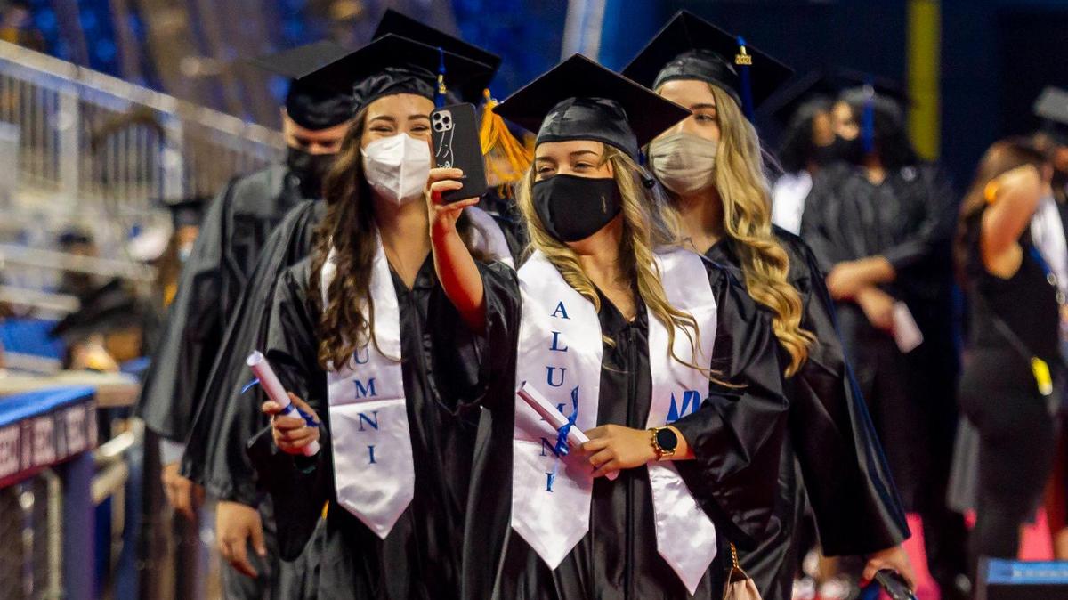 Miami Dade College students take a selfie during their graduation ceremony inside loanDepot park in Miami, Florida on Saturday, May 1, 2021.