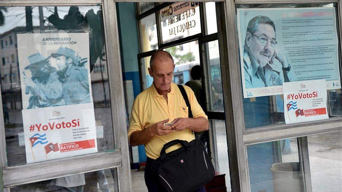 A man leaves a Havana cafeteria where posters in the windows urge Cubans to vote Yes on a new constitution.