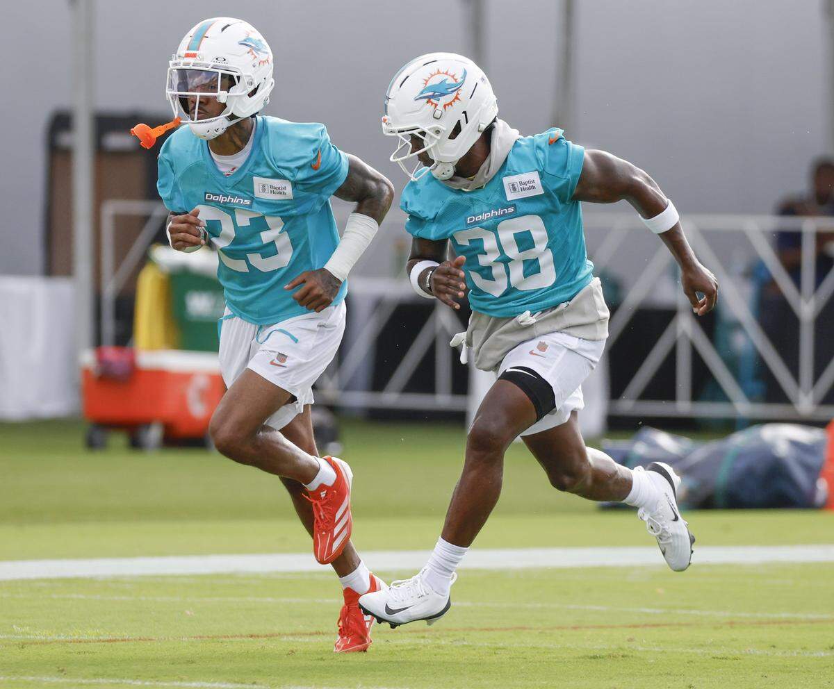 Miami Dolphins cornerback Jack Jones (23) and cornerback Mike Hillton (38) run through drills during practice at the Miami Dolphins Training Camp in Miami Gardens, Florida, on Monday, July 28, 2025.