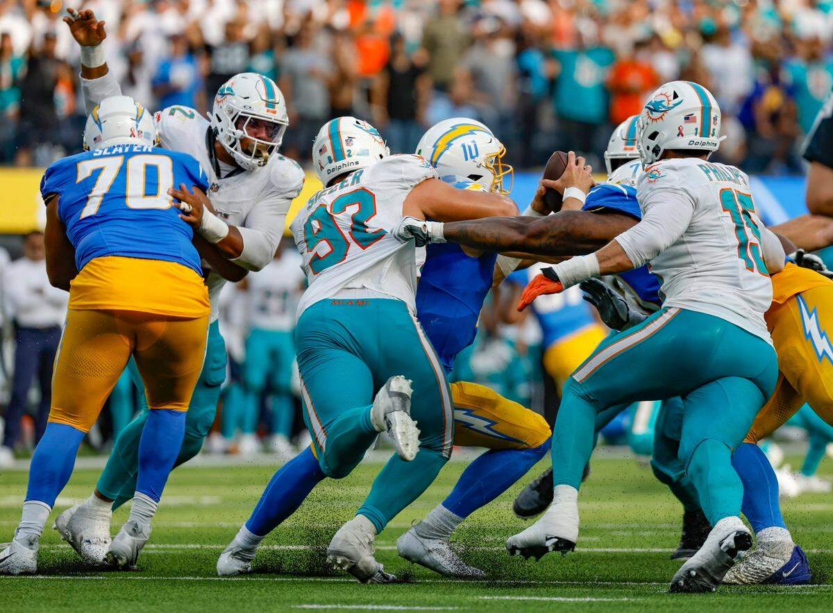 Miami Dolphins defensive tackle Zach Sieler (92) and the Dolphins defense sack Los Angeles Chargers quarterback Justin Herbert (10) late in the fourth quarter at SoFi Stadium in Inglewood, California on Sunday, September 10, 2023.