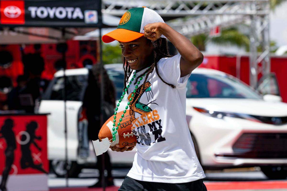 FAMU fan Eric Pressley II, 8, flexes after making a contested catch during the tailgate before the Orange Blossom Classic featuring Florida A&M University and Jackson State University at Hard Rock Stadium in Miami Gardens, Florida, on Sunday, September 5, 2021.