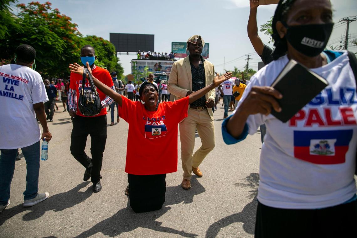 A demonstrator kneels as he chants anti-gay slogans during a protest against gay rights in Port-au-Prince, Haiti, Sunday, July 26, 2020.