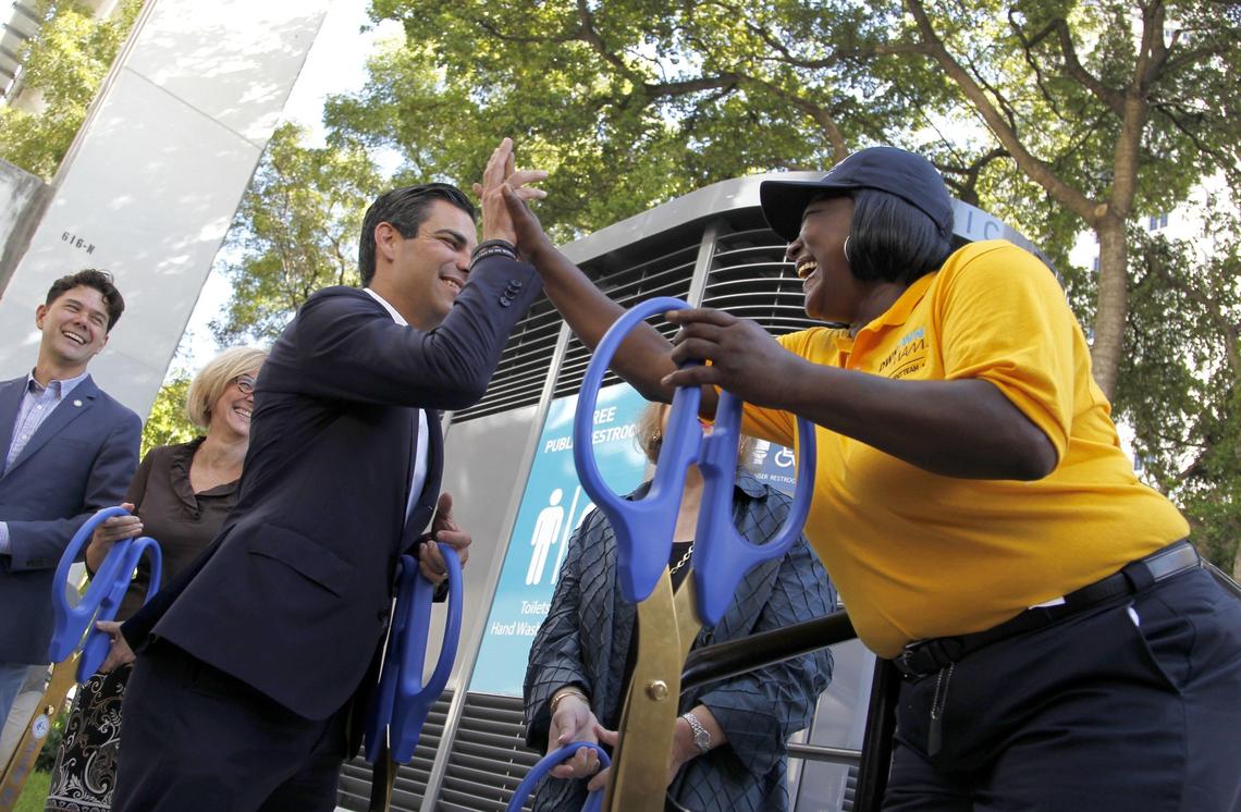 After the ribbon-cutting on Wednesday, Sept. 19, 2018, Mayor Francis Suarez, left, shares in the accomplishment of the grand opening of the first downtown public restroom near the entrance to Miami-Dade Main Library with Cassandra Strozier, 54, right, who was once homeless, and now is gainfully employed as an attendant who helps operate and clean the facility.