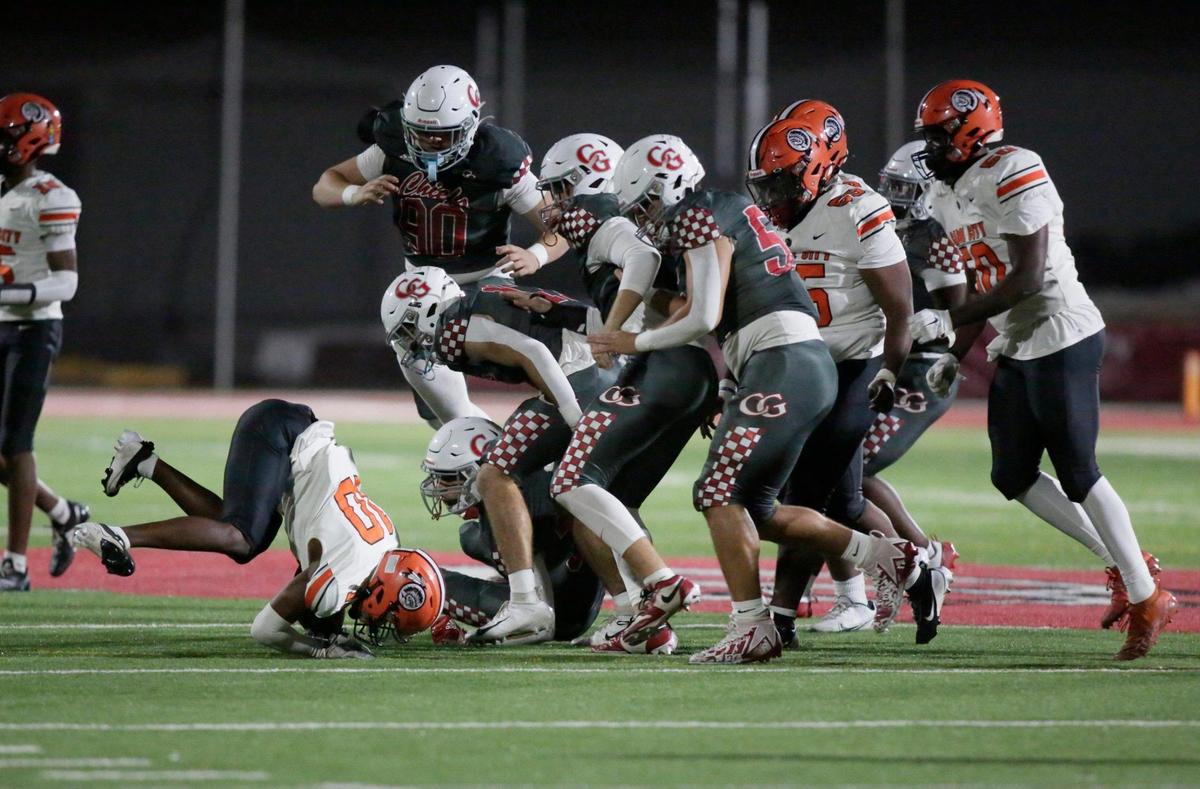 Carol City Chiefs running back Ishmael “Trap” McNichols is taken down by Cardinal Gibbons Chiefs defenders during regional quarterfinal football game on Friday, November 15, 2024 at Cardinal Gibbons HS in Fort Lauderdale. Andrew Uloza / for Miami Herald