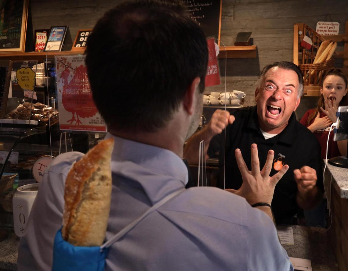 Cori Finot carries his baguette inside the Baguette Sack to the anger of Claude Pastel, center, owner of Cafe Creme in North Miami. Left to Right; Cori Finot, Claude Pastel and Lana Tymchenko.