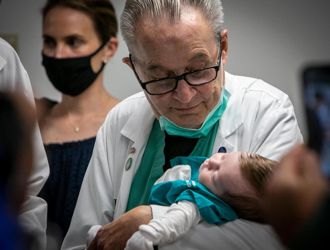 Dr. Barth A. Green holds his youngest grandchild, 8-week-old Theo Jerome Arison, during a small ceremony where colleagues paid tribute to the doctor. On Friday, May 28, 2021, Green — world-renowned neurosurgeon and humanitarian — performed his last surgery at Jackson Memorial Hospital in Miami. As he held the baby, Green extolled the power of caring for patients as though they were family.