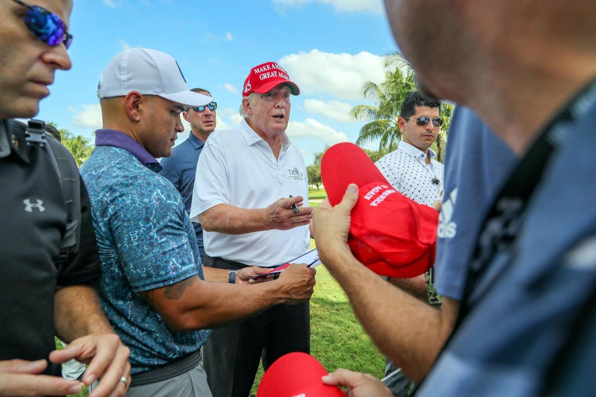 Former President Donald Trump stops to sign autographs during the LIV Golf Miami Team Championship Pro-Am Tournament at Trump National Doral Golf Club in Doral on Thursday, Oct. 27, 2022.