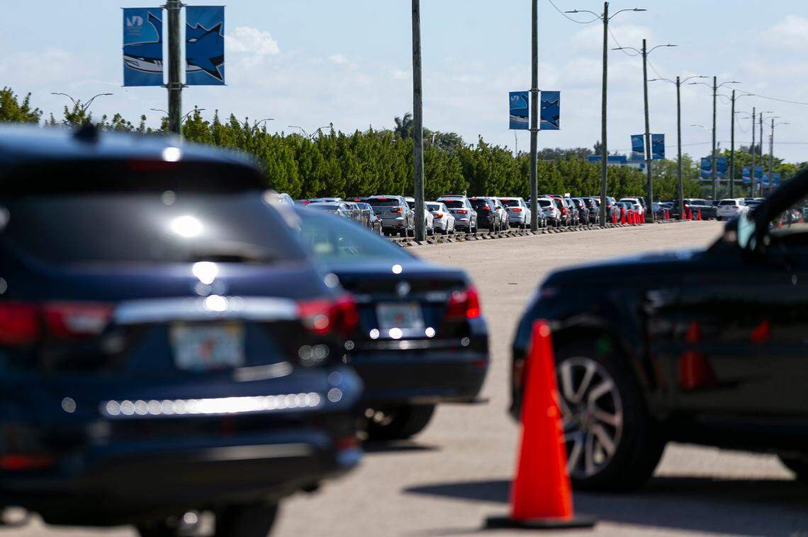 A long line of cars forms as people arrive at the Miami Dade College North vaccination site in Miami, Florida, to try and receive a COVID-19 vaccine on Sunday, March 7, 2021.