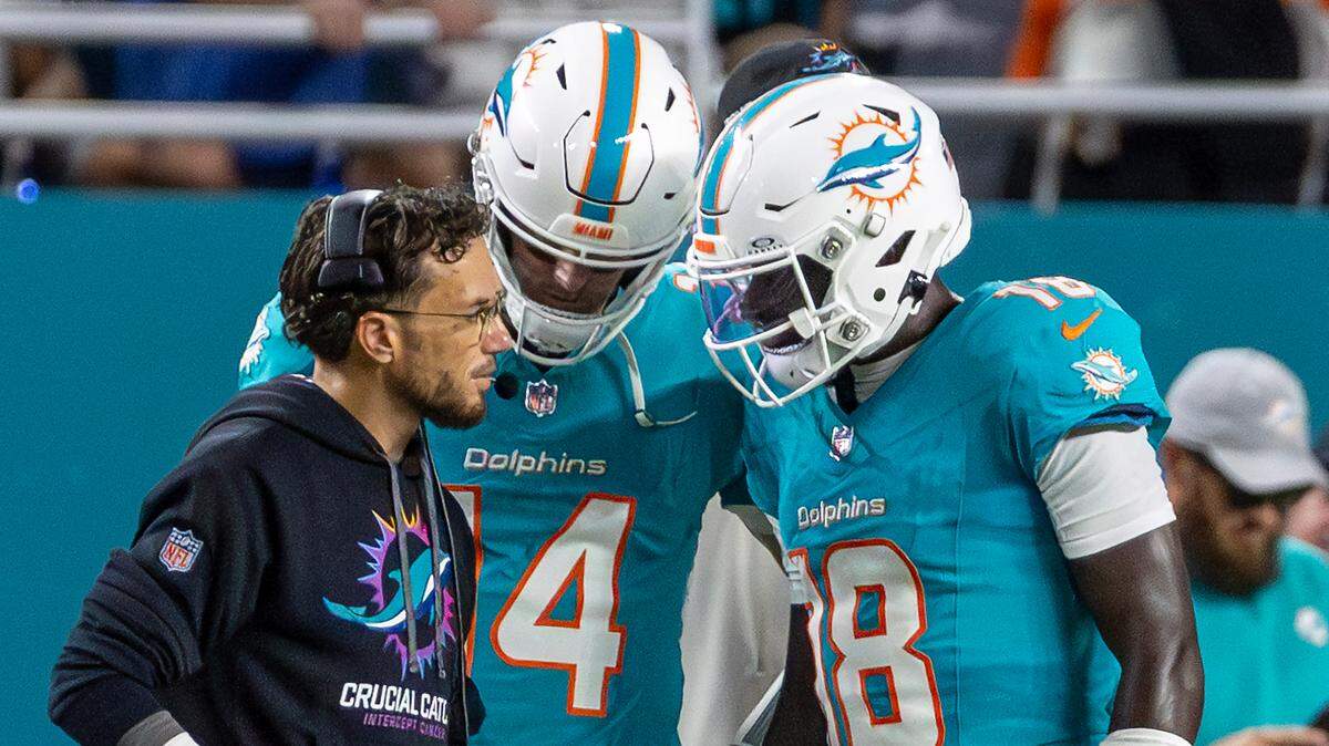 El entrenador de los Dolphins Mike McDaniel habla con los quarterbacks Tim Boyle (14) y Tyler Huntley (18), en la primera mitad del partido de la NFL contra los Titans de Tennessee, el 30 de septiembre de 2024, en Miami Gardens, Florida.