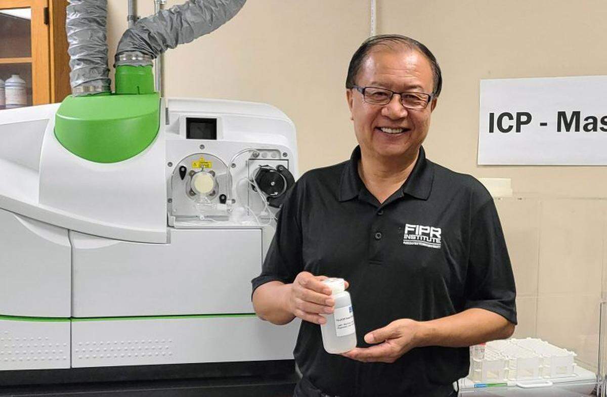 Dr. Patrick Zhang, research director of phosphate beneficiation and mining at the Florida Industrial and Phosphate Research Institute, part of Florida Polytechnic University, shows a solution containing rare earth minerals in the institute’s lab.
