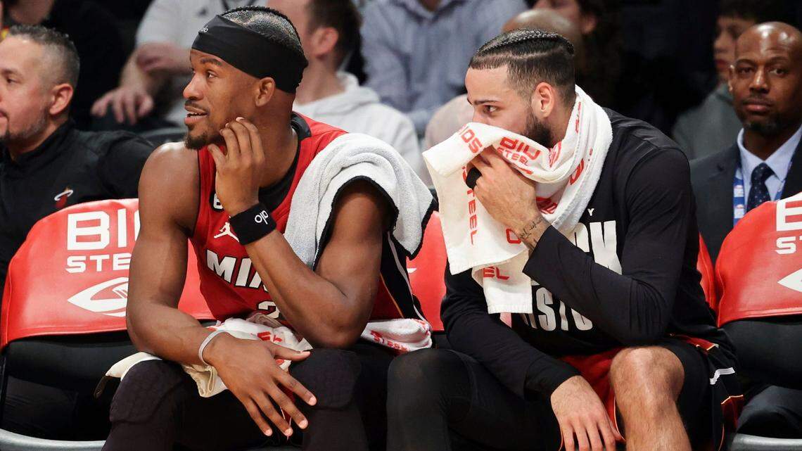 Miami Heat forwards Jimmy Butler and Caleb Martin watch play during the first half of an NBA basketball game against the Brooklyn Nets, Wednesday, Feb. 15, 2023, in New York.