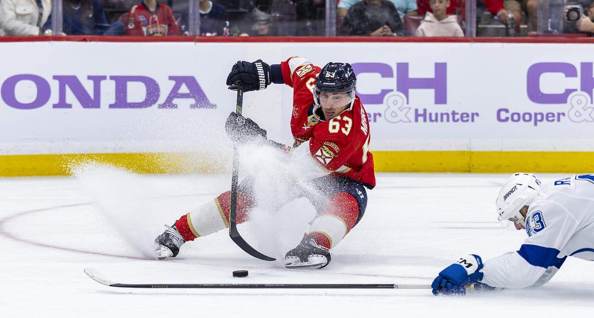 Florida Panthers left wing Brad Marchand (63) tries to control the puck as Tampa Bay Lightning defenseman Darren Raddysh (43) defends in the third period of their NHL game at the Amerant Bank Arena on Saturday, Nov. 15, 2025, in Sunrise, Fla.