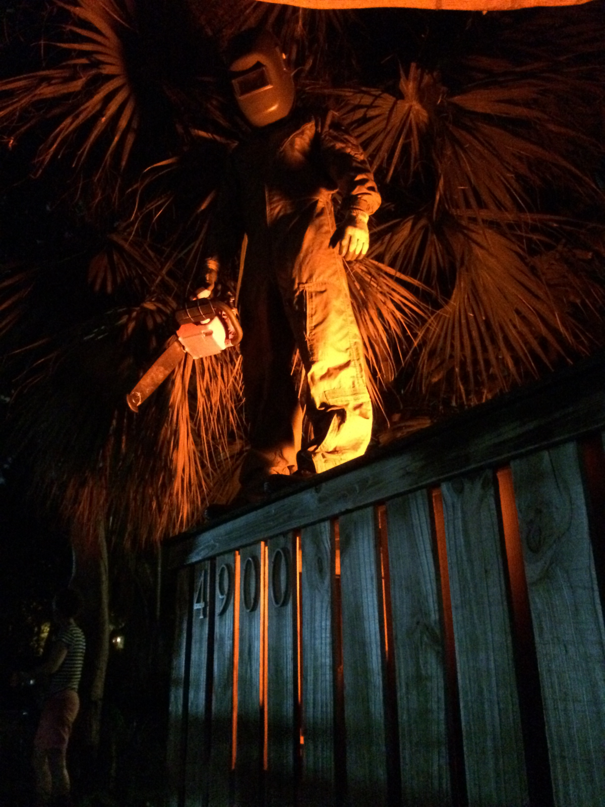 On Halloween, Noah Mostkoff stands on the wall in front of his parents’ house holding a chainsaw with no chain.