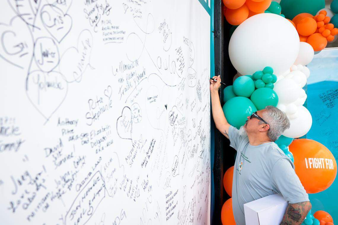 Manuel Nuno, 45, signs a poster before his 5K race during the Dolphins Cancer Challenge XVI event at Hard Rock Stadium on Saturday, Feb. 28, 2026, in Miami Gardens, Florida.