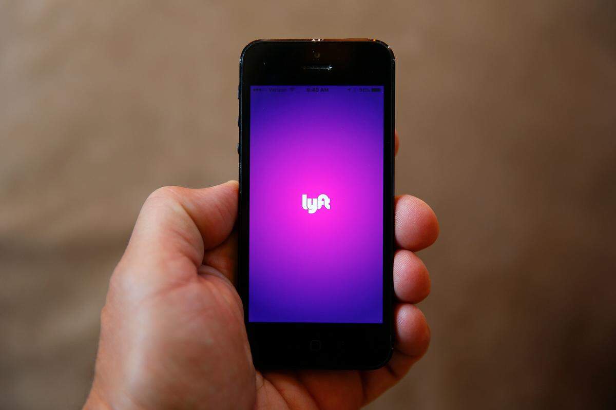 This file photo shows a smartphone displaying the Lyft app.