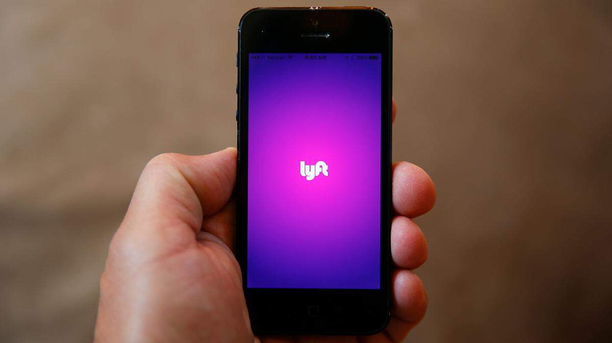 This file photo shows a smartphone displaying the Lyft app.