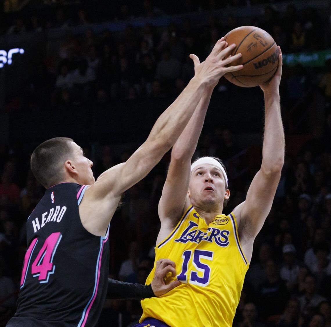 Los Angeles Lakers guard Austin Reaves (15) shoots around Miami Heat guard Tyler Herro (14) during the second half of a game on Thursday, March 19, 2026, at the Kaseya Center in downtown Miami, Fla. 