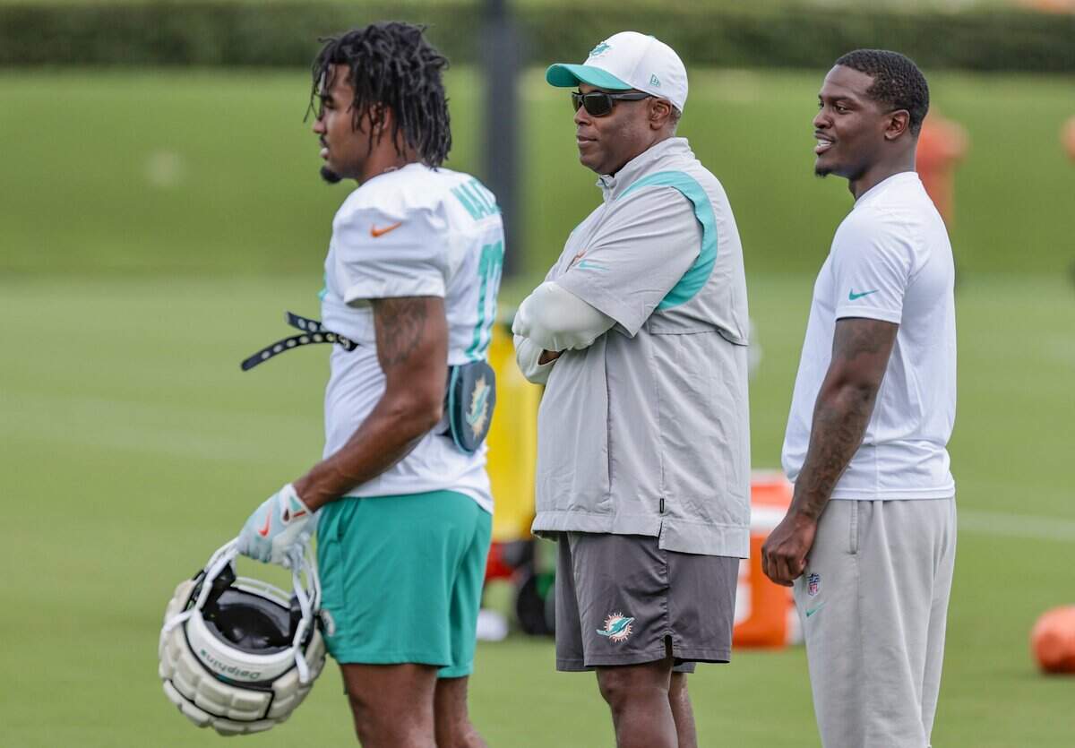 Miami Dolphins wide receiver Jaylen Waddle (17), general manager Chris Greer and running back De'Von Achane (28), left to right, watch practice drills at the Miami Dolphins Training Camp in Miami Gardens, Florida, on Wednesday, August 27, 2025.