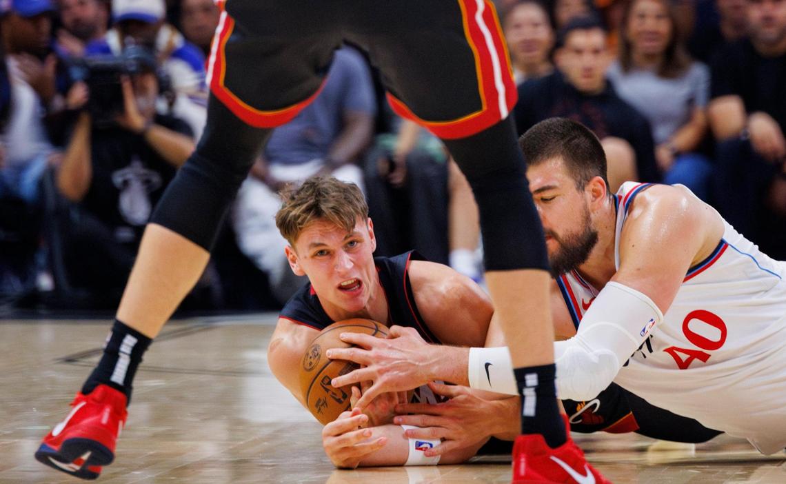 Miami Heat guard Pelle Larsson (9) grabs the ball from LA Clippers center Ivica Zubac (40) during the first half of a game and Miami Heat forward Duncan Robinson (55) watches on March 12, 2025, at Kaseya Center in Miami.