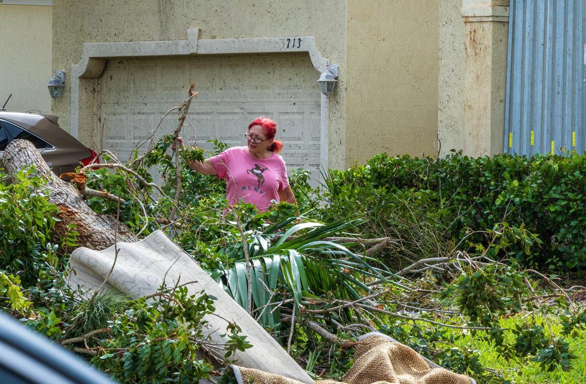 On Friday, Oct. 11, 2024, Danna Sturtsman piles branches from trees knocked down by a pair of tornadoes that tore through the Portofino Shores Community in St. Lucie County, spawned by Hurricane Milton.