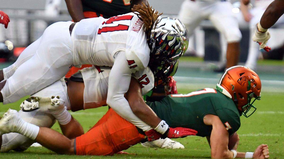 Florida A&M quarterback Junior Muratovic (7) is tackled by Jackson State defensive back Cam’Ron Silmon (12) and linebacker James Houston IV (41) on fourth down late in the fourth quarter of an NCAA college football game, Sunday, Sept. 5, 2021, in Miami Gardens, Fla. (AP Photo/Jim Rassol)
