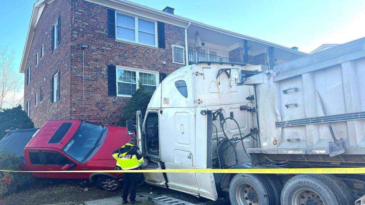 A collision caused a semitruck driver to lose control and smash into a condo building, injuring four, Virginia police said.
