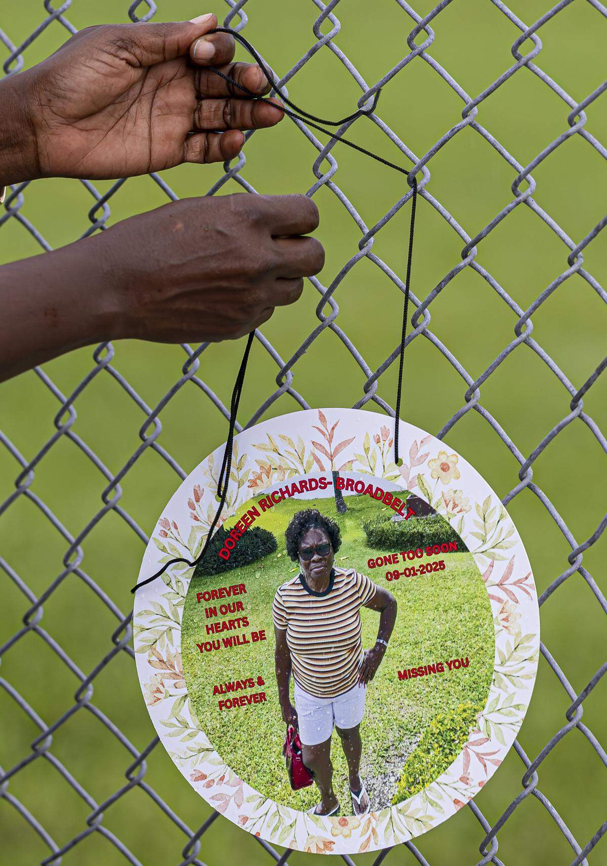 Shelley Ann Williams hangs a photo as she visits a makeshift memorial for her mother, Doreen Richards Broadbelt, 71, who police said was walking to her job at Walmart when a dog attacked and fatally mauled her near her home on Labor Day. A vigil was held nearby at Broadbelt's home on Tuesday, Sept. 9, 2025, in Miami Gardens, Fla.