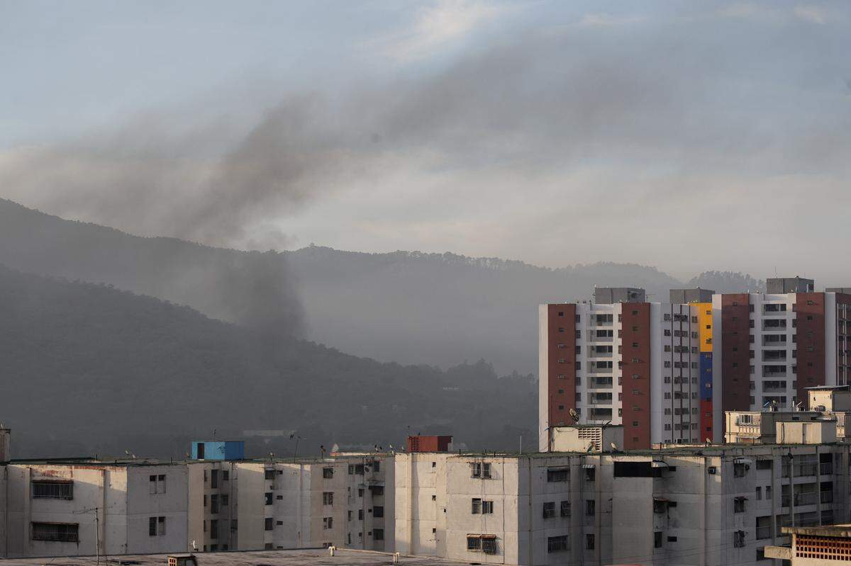 Smoke is seen over buildings after explosions and low-flying aircraft were heard on January 03, 2026 in Caracas, Venezuela. According to some reports, explosions were heard in Caracas and other cities near airports and military bases around 2 am. US President Donald Trump later announced that his country's military had launched a "large-scale" attack on Venezuela and captured its President Nicolas Maduro and his wife. (Photo by Jesus Vargas/Getty Images)
