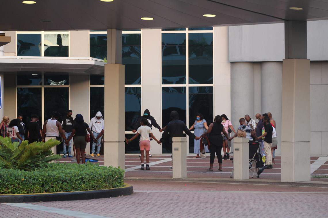 Friends and family of some of the 20 to 25 injured in the Sunday mass shooting gathered together to pray outside the Ryder Trauma Center at Jackson Memorial Hospital.