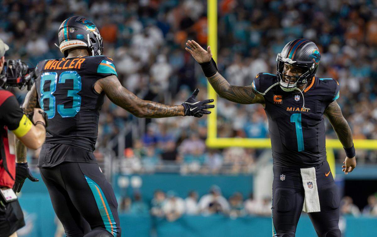 Miami Dolphins tight end Darren Waller (83) celebrates with quarterback Tua Tagovailoa (1) after scoring his second touchdown against the New York Jets during the second half of an NFL game at Hard Rock Stadium on Monday, Sept. 29, 2025, in Miami Gardens, Fla..