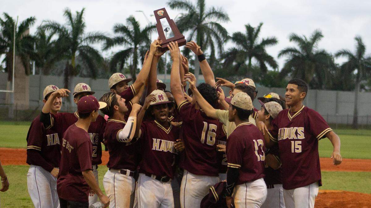 Miami Springs players celebrate and hold up their district championship trophy following an 8-2 victory over Goleman in the District 16-6A championship game Thursday evening at Hialeah-Miami Lakes High School.