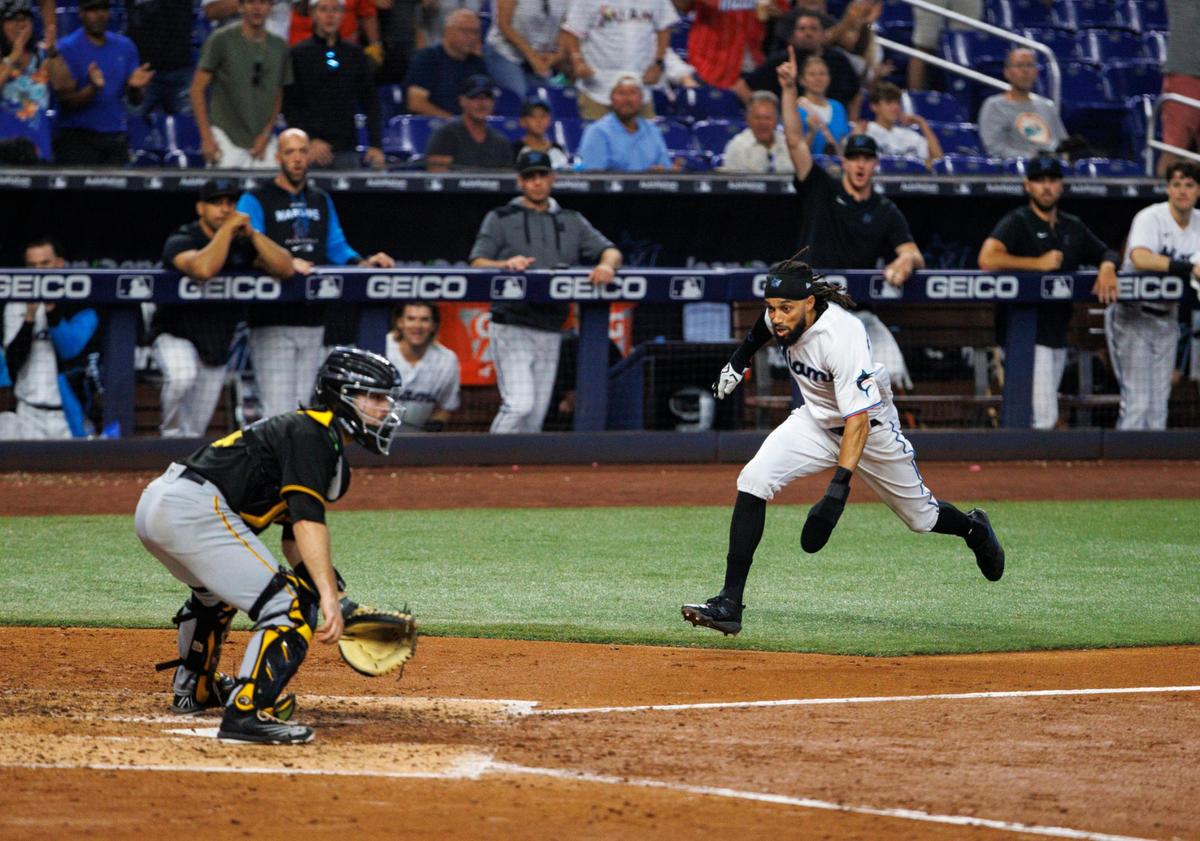 Pittsburgh Pirates catcher Jason Delay (61) waits for the throw as Miami Marlins center fielder Billy Hamilton (6) runs to scores during the fifth inning of a baseball game at LoanDepot Park on Thursday, July 14, 2022 in Miami, Florida.