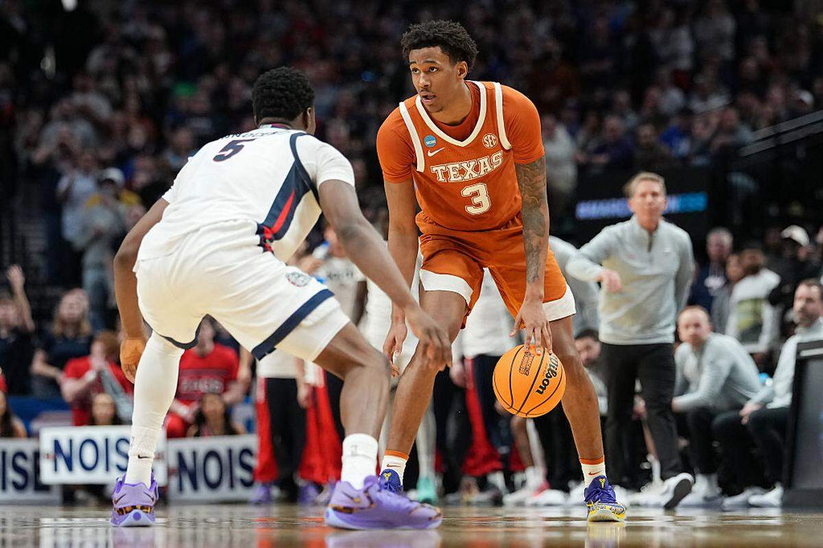 Dailyn Swain #3 of the Texas Longhorns dribbles the ball while being guarded by Emmanuel Innocenti #5 of the Gonzaga Bulldogs during the second half in the second round of the 2026 NCAA Men's Basketball Tournament at Moda Center on March 21, 2026 in Portland, Oregon.