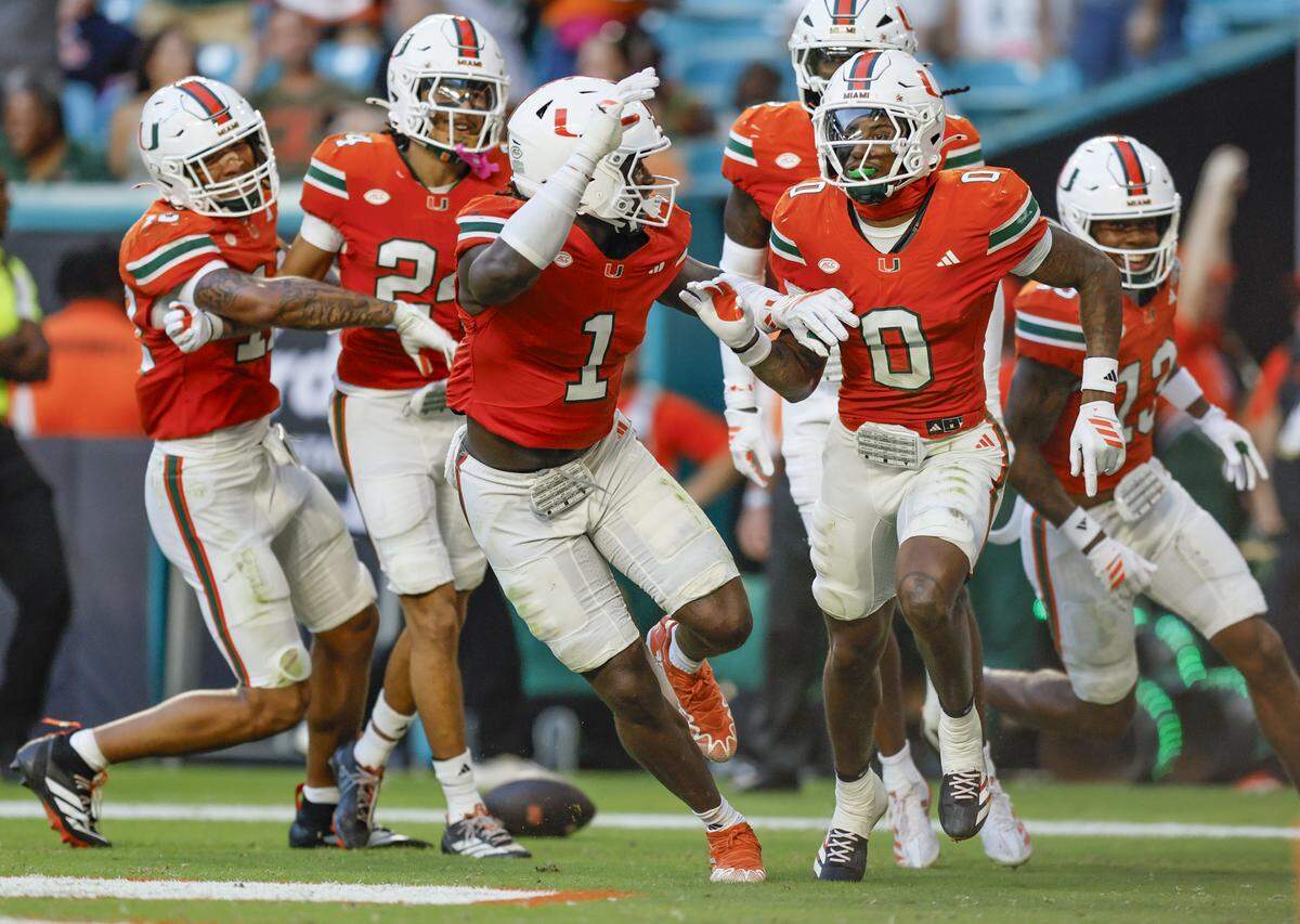 Miami Hurricanes linebacker Mohamed Toure (1) and defensive back Keionte Scott (0) celebrate Scott’s pick six in the first half during an NCAA football game at Hard Rock Stadium against Syracuse Orange in Miami Gardens, Florida on Saturday, November 8, 2025.