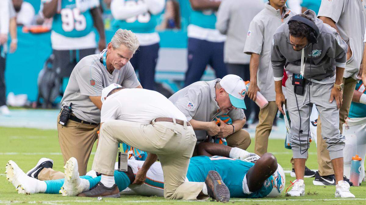 Miami Dolphins head coach Mike McDaniel talks with offensive tackle Kion Smith (71) after sustaining an injury following a play against the Atlanta Falcons in the first quarter of their NFL pre-season football game at Hard Rock Stadium on Friday, Aug. 9, 2024, in Miami Gardens, Fla.