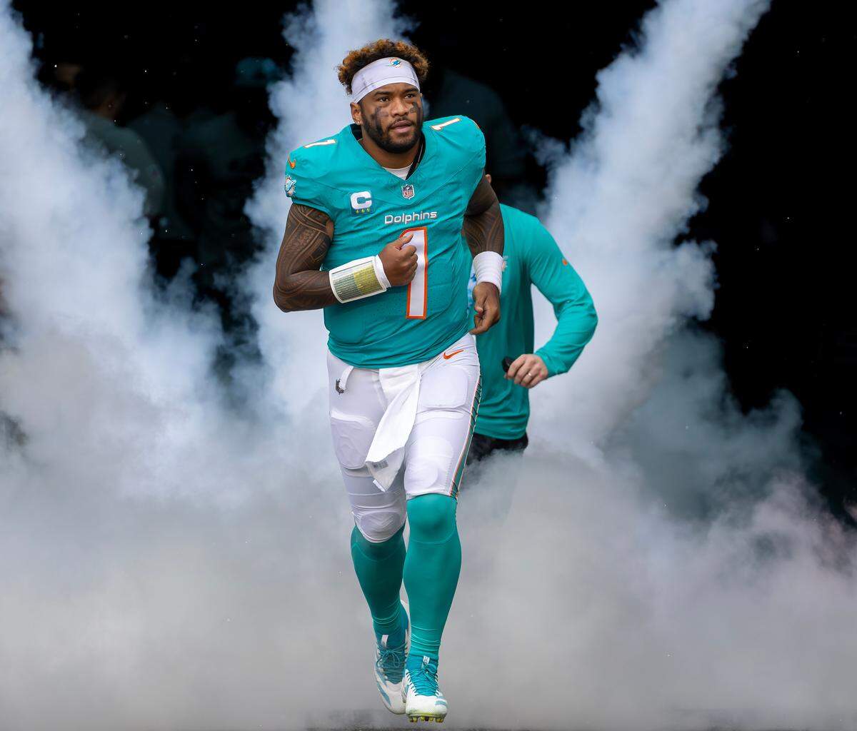 Miami Dolphins quarterback Tua Tagovailoa (1) runs out of the tunnel onto the field before the start of their NFL game against the San Francisco 49ers at Hard Rock Stadium on Sunday, Dec. 22, 2024, in Miami Gardens, Florida.