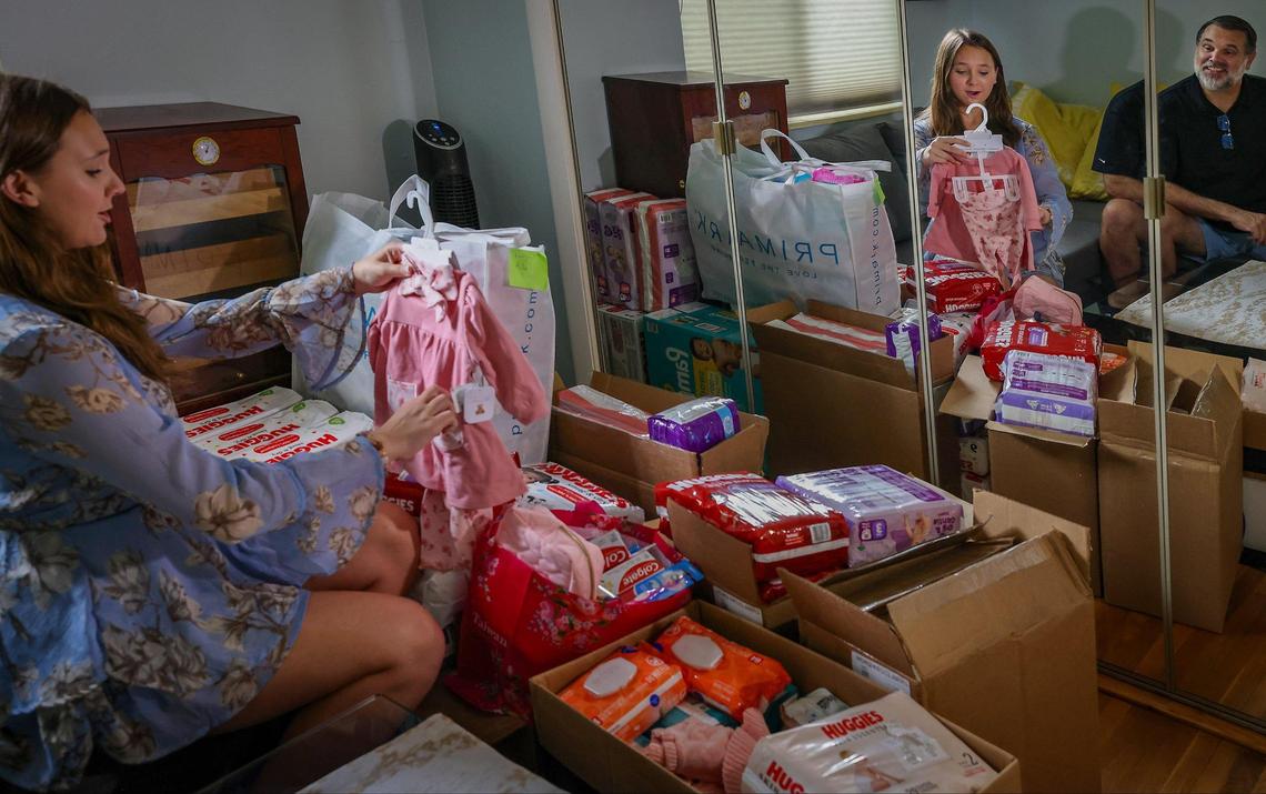Mina Boomer, left, and her father, Mark Boomer, right, sort and prepare to deliver about 3,000 diapers, 88 baby bottles, 82 makeup kits, toothbrushes, and other items to a high school in Miami-Dade for pregnant and parenting teenage girls.
