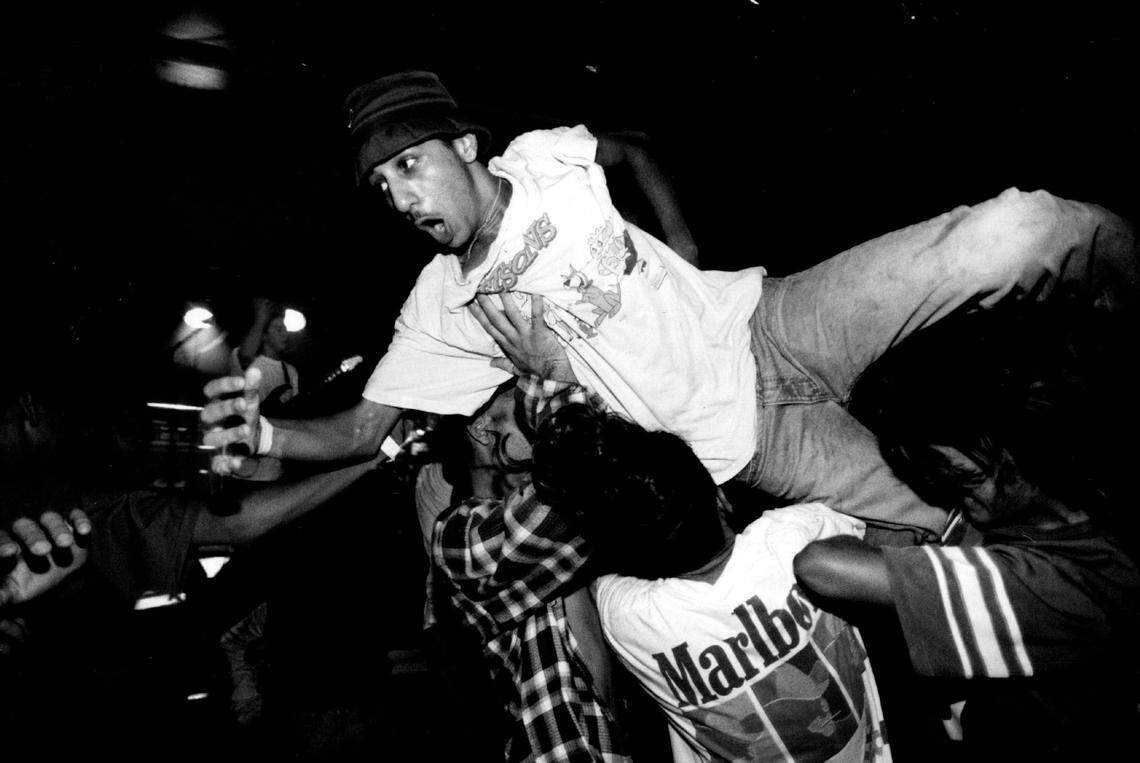 A clubgoer gets carried through and over the crowd after jumping head first off of the stage during a show at Washington Square on South Beach in 1993.