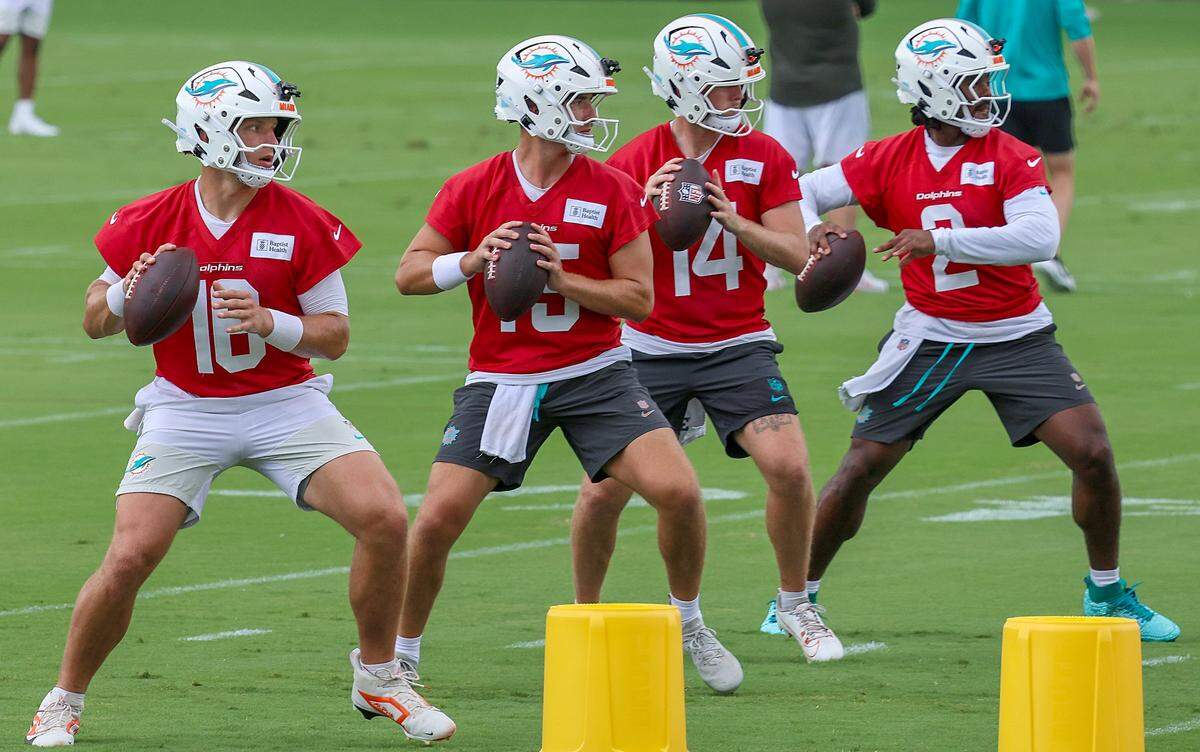 Quarterbacks Mark Gronowski (16), left, Cam Miller (15), Quinn Ewers (14), and Malik Willis (2), perform passing drills during the Dolphins minicamp at the team's training facility in Miami Gardens on Monday, June 3, 2026. 