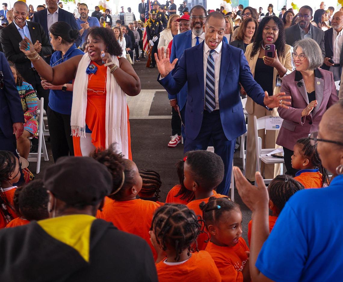 Eric Scott Turner, Secretary of Housing and Urban Development, center, enjoys a performance by the children of Easter Seals Head Start & Early Head Start Program as Miami-Dade Mayor Daniela Levine Cava, right, looks on during the opening of the ribbon-cutting ceremony of Serenity of Liberty Square to mark the opening of phase four in a nine-phase redevelopment project.