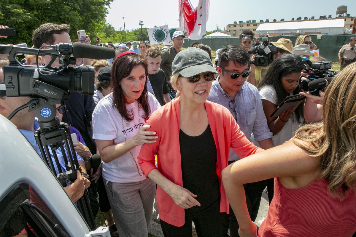 Democratic presidential candidate Elizabeth Warren is swarmed by the press while walking past the Homestead detention center for migrant children in Homestead, Florida, ahead of the first Democratic debates in Miami, on Wednesday, June 26, 2019.