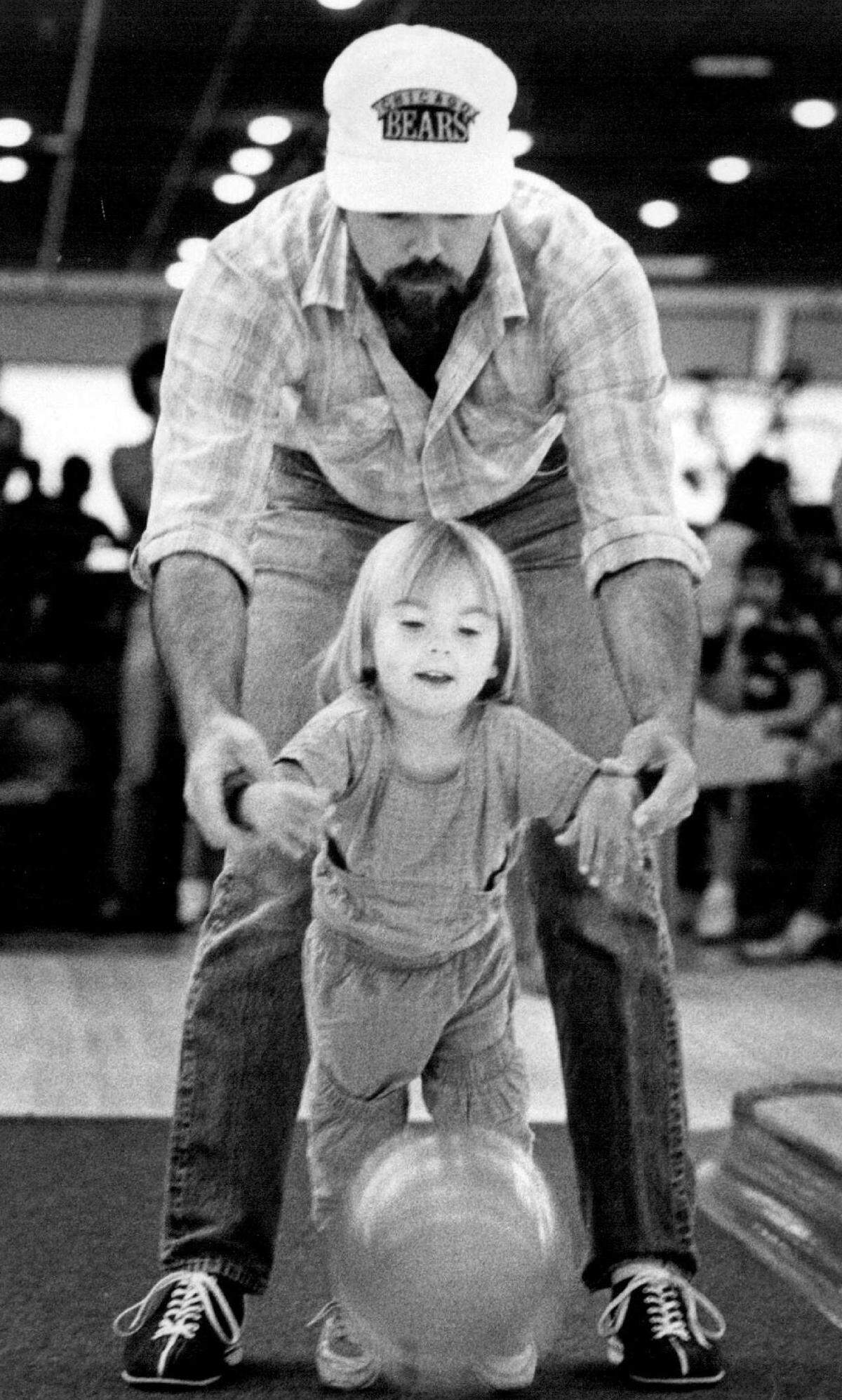 Gary Yohe helps his neighbor, Stephanie Wright, 3, at Don Carter’s Tamarac Bowling Center in 1986.