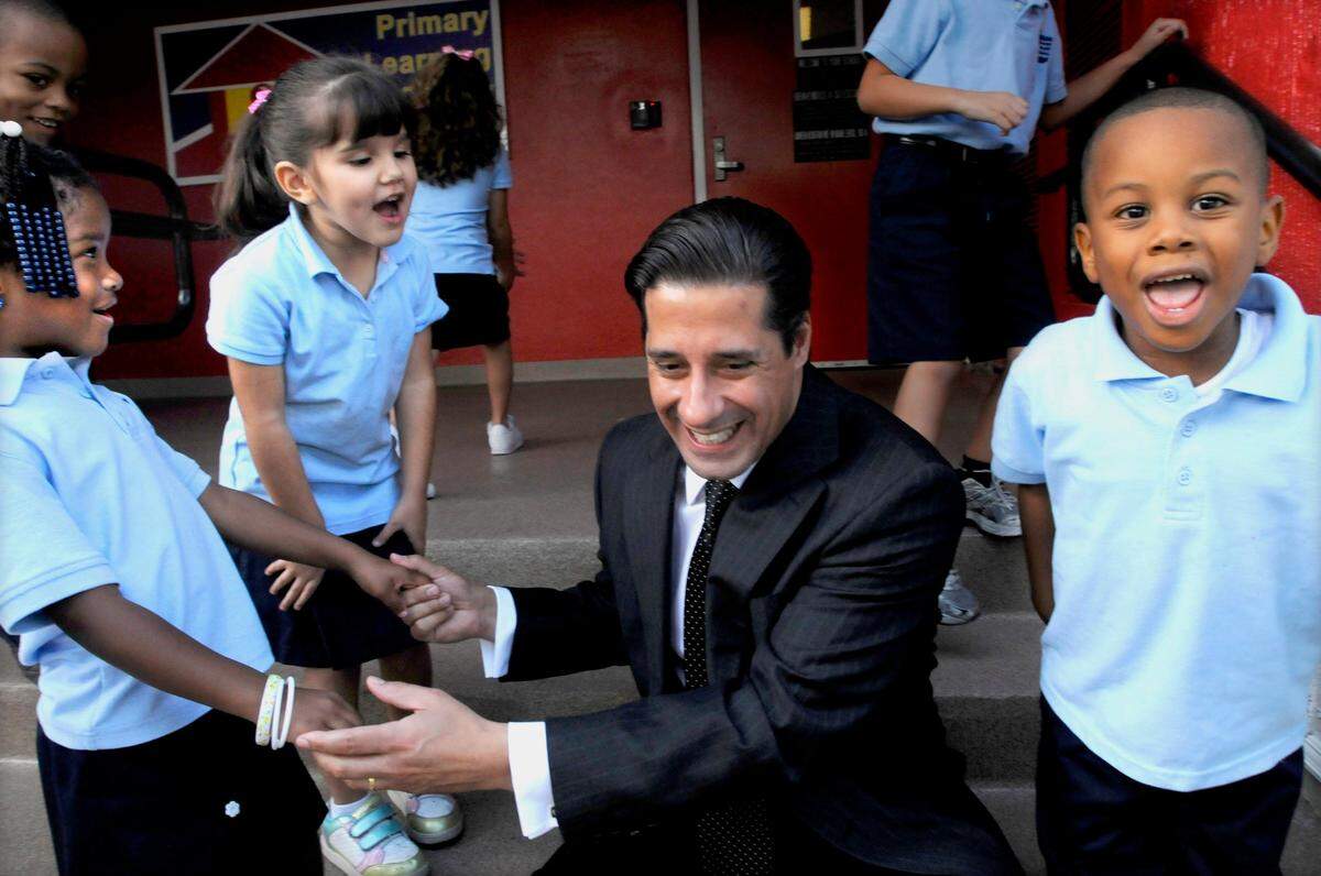 Miami-Dade School Superintendent Alberto Carvalho is welcomed by students, Maryn Anderson, 5, left, Taylor Lopez, 5, center, and Eldridge Paschal, 4, from the Primary Learning Center, located in the School Board Annex, where he is principal. The school opened in 2009 and would become iPrep Academy, which is now from pre-K to 12th grade.