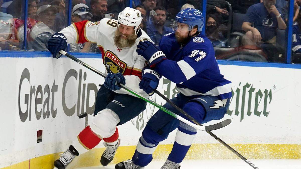Florida Panthers center Joe Thornton (19) and Tampa Bay Lightning defenseman Victor Hedman (77) chase a loose puck during the first period in Game 4 of an NHL hockey second-round playoff series Monday, May 23, 2022, in Tampa, Fla. (AP Photo/Chris O’Meara)