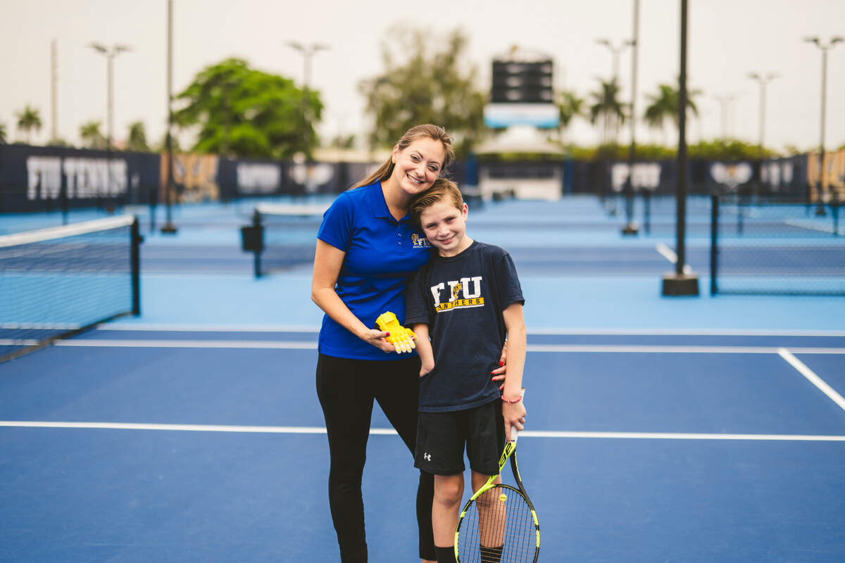 Amanda Thomas, clinical assistant professor for physical therapy at Florida International University, poses with her son Hayden at the tennis courts located on Florida International University’s main campus on Southwest Eighth Street. Thomas created a new at-home exercise program to help kids like her son learn how to use 3D prosthetics.