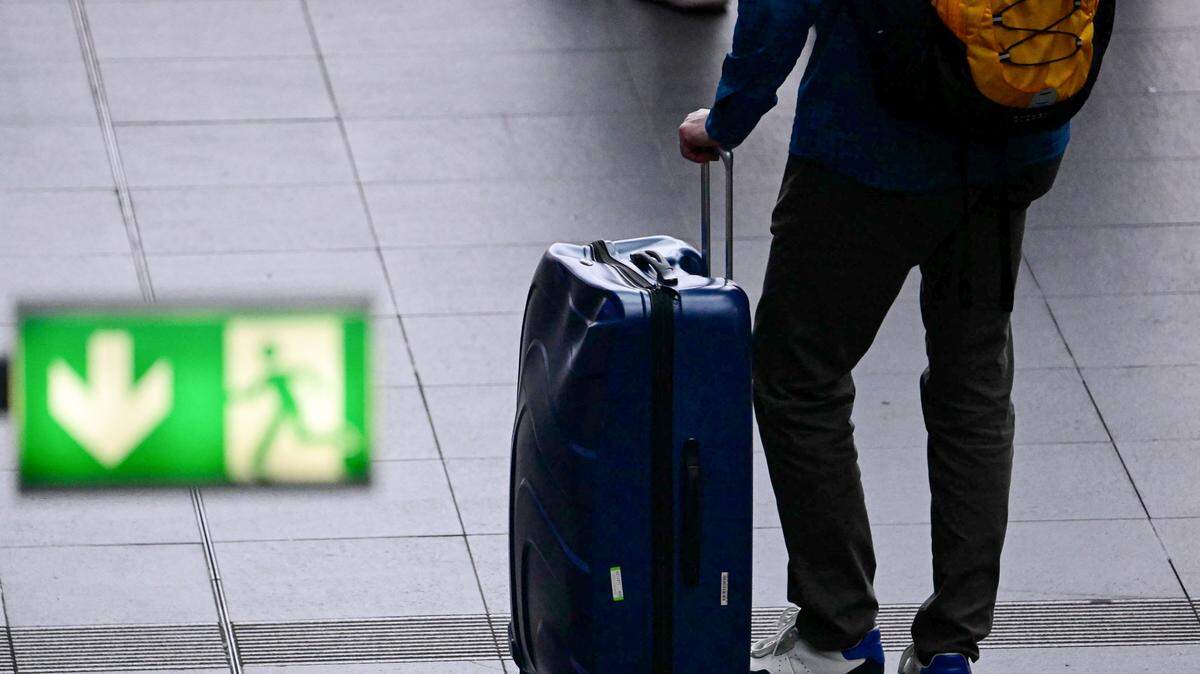 A tourist walks with his suitcase at the main train station (Haputbahnhof) in Berlin on July 17, 2025.