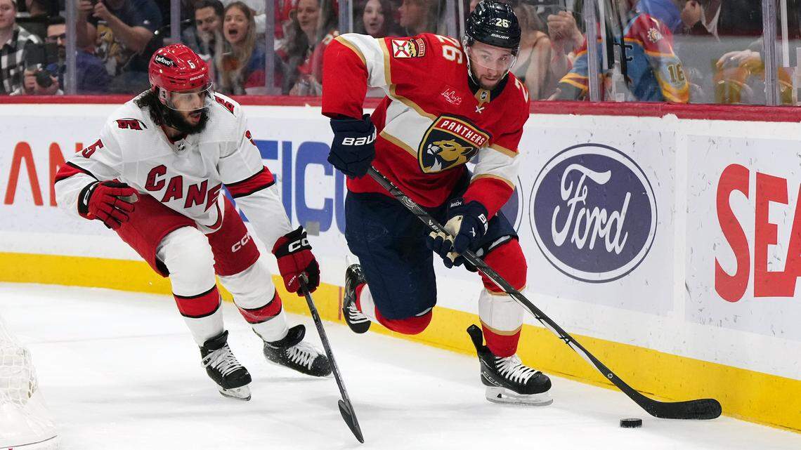 Nov 10, 2023; Sunrise, Florida, USA; Florida Panthers defenseman Uvis Balinskis (26) controls the puck away from Carolina Hurricanes defenseman Jalen Chatfield (5) during the second period at Amerant Bank Arena. Mandatory Credit: Jasen Vinlove-USA TODAY Sports